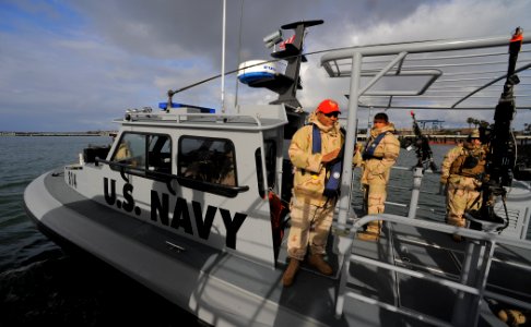 US Navy 100422-N-4965F-005 Sailors assigned to a boat detachment of Maritime Expeditionary Security Squadron (MSRON) 3 man a rigid-hull inflatable boat during a Navy Expeditionary Combat Command (NECC) integrated exercise