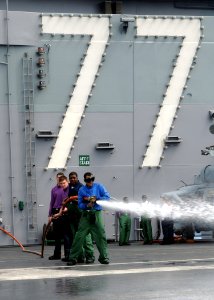 US Navy 100427-N-7908T-212 Sailors aboard the aircraft carrier USS George H.W. Bush (CVN 77) wash down the flight deck during a scrubbing exercise in preparation for the ship's first Friends and Family Day Cruise