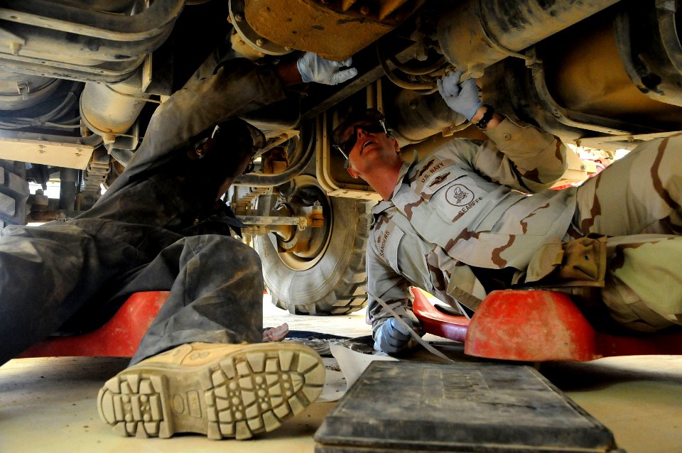 US Navy 100429-N-0475R-419 Construction Mechanic Constructionman Isiah Sanders shows Cmdr. Scot Sanders proper procedures for conducting a maintenance spot check on a 5-ton tractor at Camp Leatherneck, Afghanistan