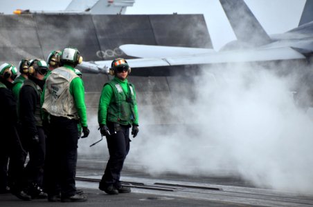 US Navy 100426-N-5749W-468 Sailors aboard the aircraft carrier USS Abraham Lincoln (CVN 72) await the launch of an F-A-18C Hornet, assigned to the Vigilantes of Strike Fighter Squadron (VFA) 151