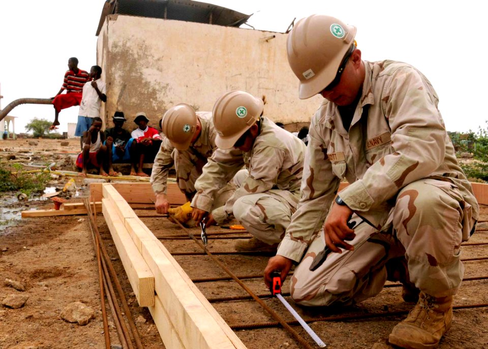 US Navy 100428-N-8936G-042 Builder Constructionman Joseph Scott, Builder Constructionman Selina Rodriguez and Equipment Operator Constructionman Apprentice Corey Moore measure and secure rebar framework on a water distribution