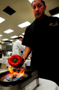 US Navy 100427-N-3659B-193 Senior Chief Culinary Specialist Eric Amador roasts a red bell pepper while preparing a dish for the 2010 Navy Region Southwest Culinary Competition