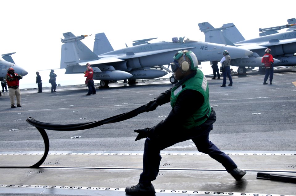 US Navy 100426-N-5749W-053 Aviation Boatswain's Mate (Equipment) Airman Michael Jones removes a catapult slot seal in preparation for an aircraft launch on the flight deck of the aircraft carrier USS Abraham Lincoln (CVN 72)