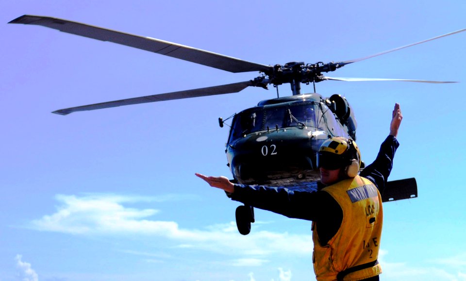 US Navy 100427-N-1675O-245 Seaman Drew Iverson directs an SH-60F Sea Hawk helicopter during flight operations aboard USS Blue Ridge (LCC 19)