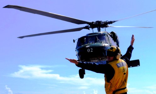 US Navy 100427-N-1675O-245 Seaman Drew Iverson directs an SH-60F Sea Hawk helicopter during flight operations aboard USS Blue Ridge (LCC 19)