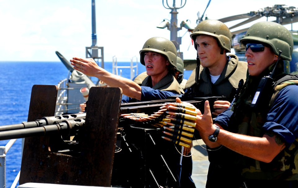 US Navy 100427-N-7280V-269 Yeoman 3rd Class Jacob Slay, center, fires a twin .50-caliber machine gun as Information Systems Technician 2nd Class Michael Ervin, left, and Gunner's Mate 2nd Class Joshua Pacheco