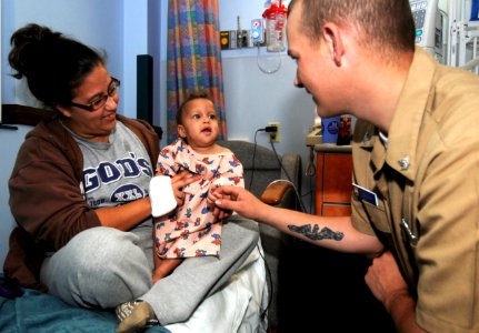 US Navy 100429-N-1522S-002 Machinist's Mate 3rd Class Patrick Gillum, visits with a child at the Joe Dimaggio Children's Hospital in Hollywood, Fla., as part of Fleet Week Port Everglades