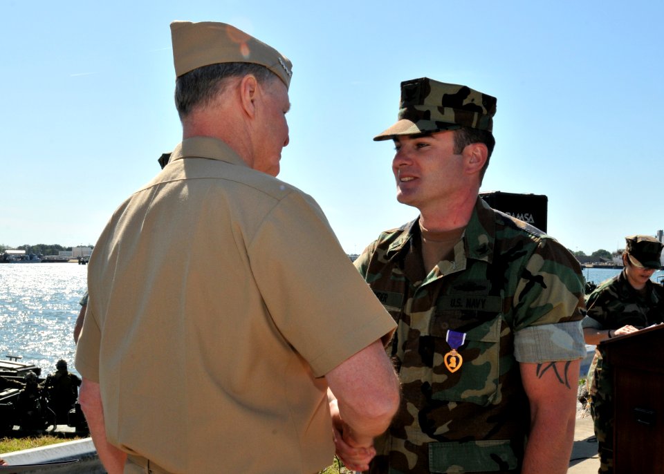 US Navy 100429-N-4267W-178 Chief of Naval Operations (CNO) Adm. Gary Roughead presents Engineman 3rd Class Daniel Snider with the Purple Heart Medal