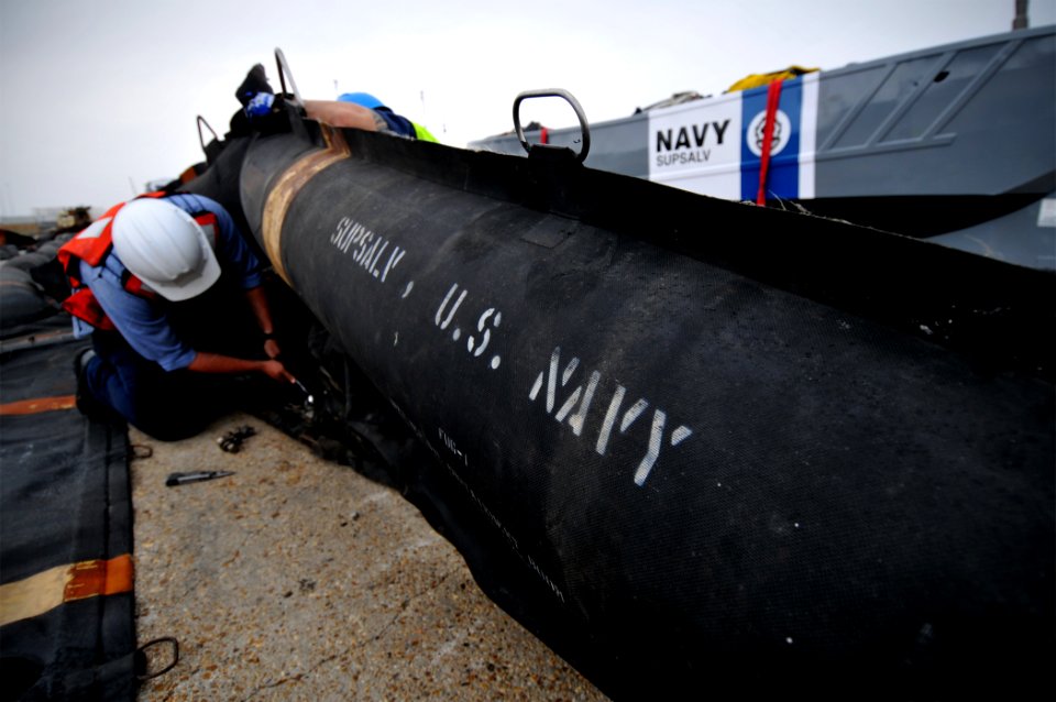 US Navy 100430-N-7367K-004 An employee of the Supervisor of Salvage and Diving division of Naval Sea Systems Command works on an oil containment boom