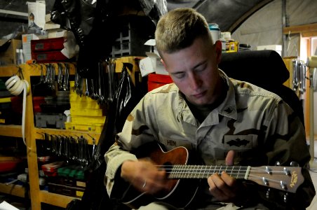 US Navy 100429-N-0475R-061 Construction Mechanic 3rd Class Preston Hein plays a ukulele during his break time at Camp Leatherneck, Afghanistan