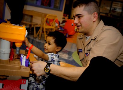 US Navy 100429-N-1522S-003 Machinist's Mate 2nd Class David McClintock visits with a child at the Joe Dimaggio Children's Hospital in Hollywood, Fla., as part of Fleet Week Port Everglades