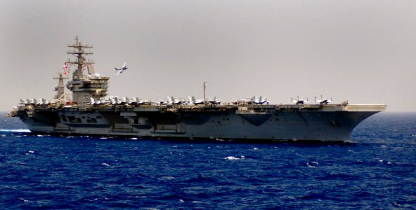 US Navy 100503-N-6854D-002 An EA-6B Prowler assigned to the Patriots of Electronic Attack Squadron (VAQ) 140 flies past the aircraft carrier USS Dwight D. Eisenhower (CVN 69)