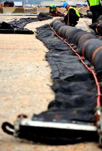 US Navy 100430-N-7367K-005 Isidro Campos inflates an oil containment boom for staging at the port of Gulfport
