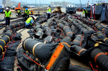 US Navy 100430-N-7367K-006 Longshoremen and personnel assigned to the Supervisor of Salvage and Diving division of Naval Sea Systems Command stage oil containment booms