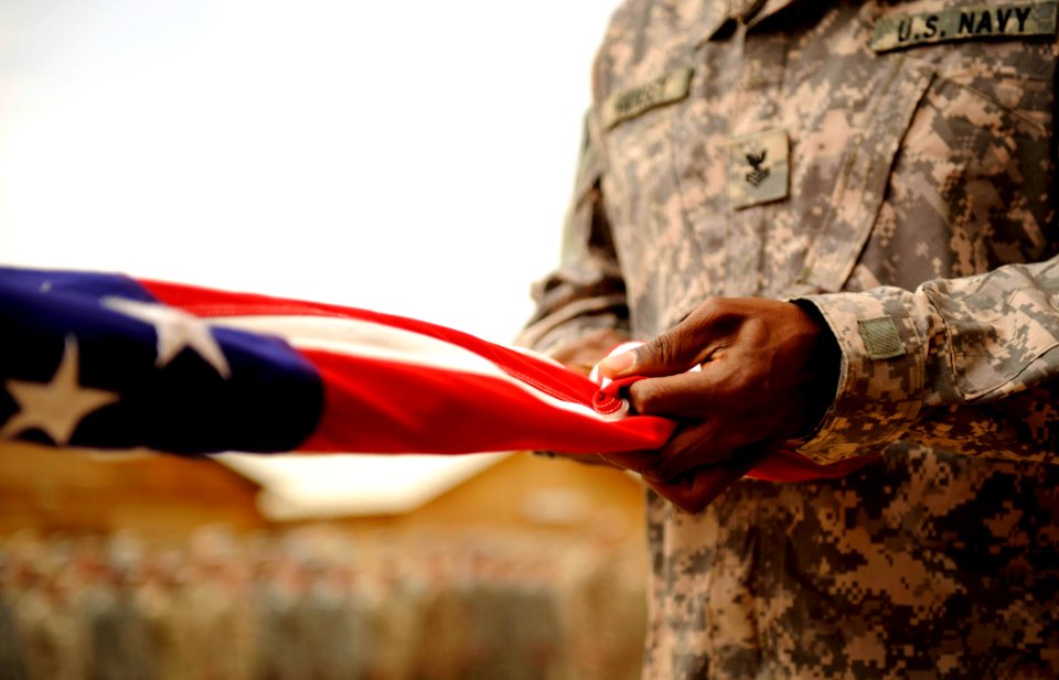US Navy 100430-N-7130B-107 A Sailor assigned to Special Operations Task Force West folds an American flag during a memorial