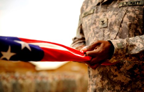 US Navy 100430-N-7130B-107 A Sailor assigned to Special Operations Task Force West folds an American flag during a memorial photo