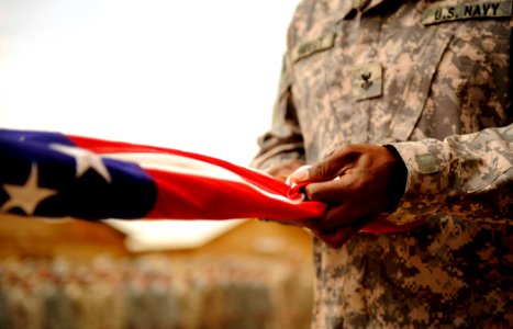 US Navy 100430-N-7130B-107 A Sailor assigned to Special Operations Task Force West folds an American flag during a memorial