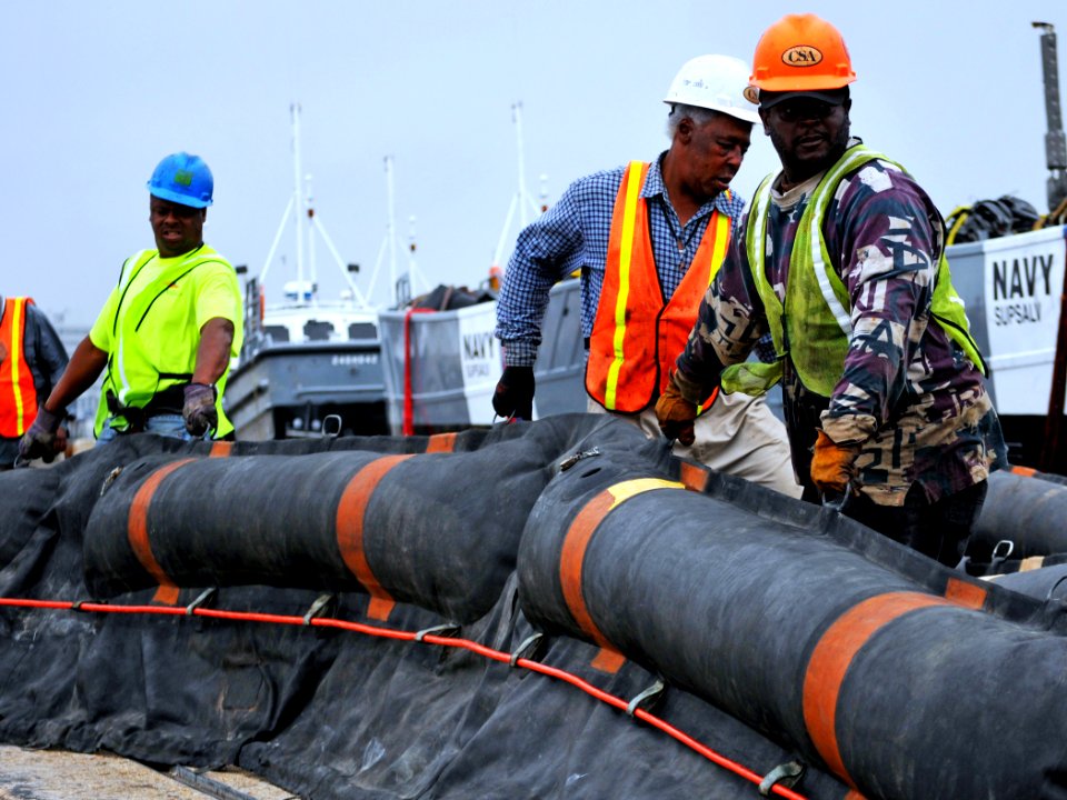 US Navy 100430-N-7367K-008 Longshoremen and personnel assigned to the Supervisor of Salvage and Diving division of Naval Sea Systems Command stage oil containment booms