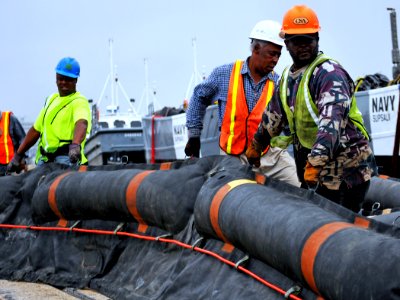 US Navy 100430-N-7367K-008 Longshoremen and personnel assigned to the Supervisor of Salvage and Diving division of Naval Sea Systems Command stage oil containment booms