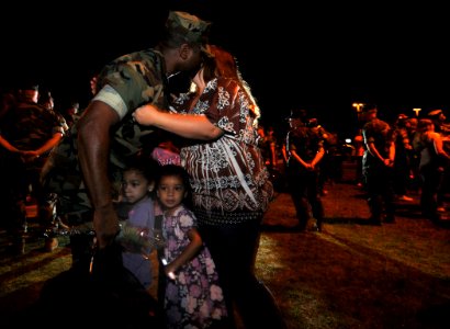 US Navy 100505-N-7367K-002 Steelworker 1st Class Elliot Sermons, assigned to Naval Mobile Construction Battalion (NMCB) 1, greets his wife and daughters during the battalion's homecoming