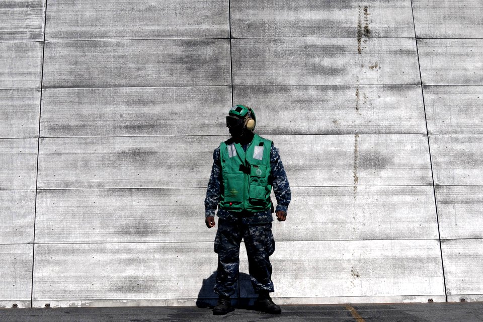 US Navy 100501-N-7605J-349 Aviation Boatswain's Mate (Equipment) Airman Recruit Kywane Lindsay-Small stands in front of a jet blast deflector (JBD) during a flight deck drill