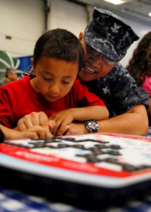 US Navy 100501-N-4516G-030 A Sailor aboard the aircraft carrier USS George H.W. Bush (CVN 77), plays with a child during the ship's inaugural Friends and Family Day