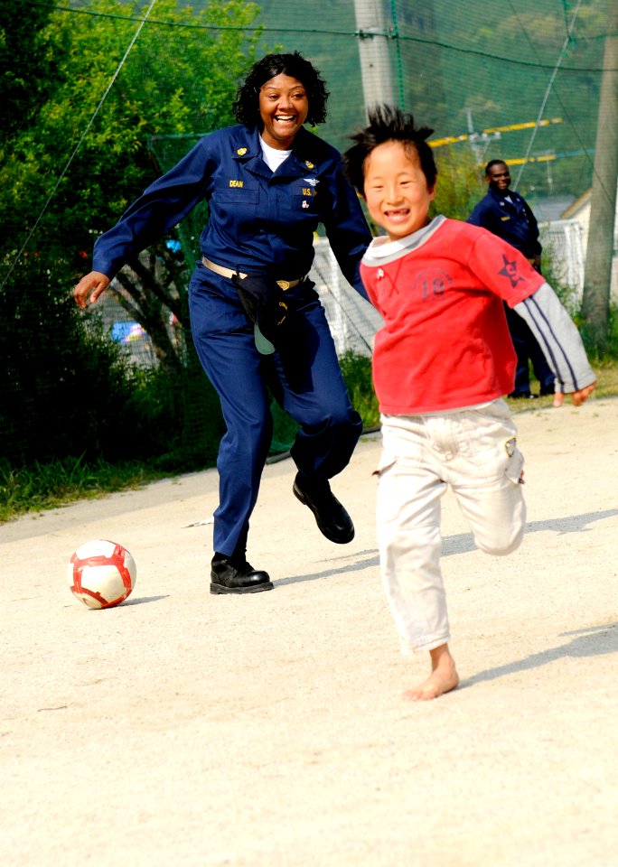 US Navy 100502-N-0864H-232 Chief Yeoman Roszetta Dean plays kickball with a child at the Kodomono-ie Children's Home