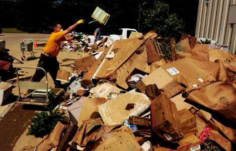 US Navy 100506-N-5862D-005 Chief Petty Officer Kevin Kaul piles waterlogged paperwork and other items that were damaged by floodwaters at the Navy Recruiting Command storage annex
