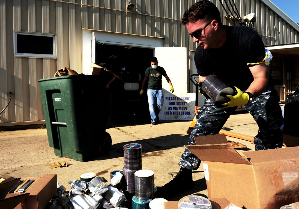 US Navy 100506-N-5862D-004 Chief Mass Communication Specialist George Kusner disposes of spools of CDs and DVDs that were damaged by floodwaters at the Navy Recruiting Command storage annex