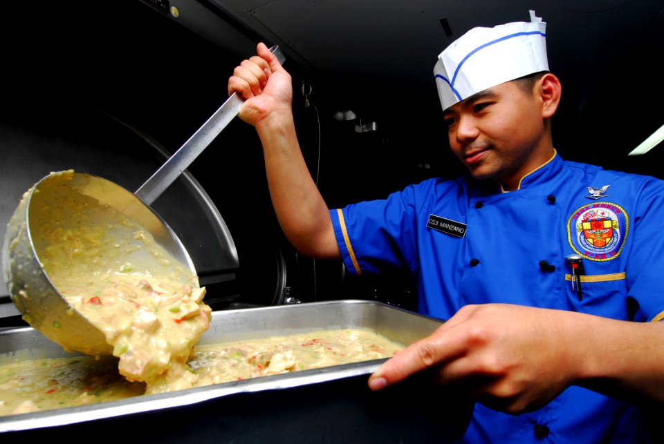 US Navy 100503-N-4044H-064 Culinary Specialist 3rd Class Jaime Manzano prepares Turkey-A-La-King for lunch aboard the Military Sealift Command hospital ship USNS Mercy (T-AH 19)