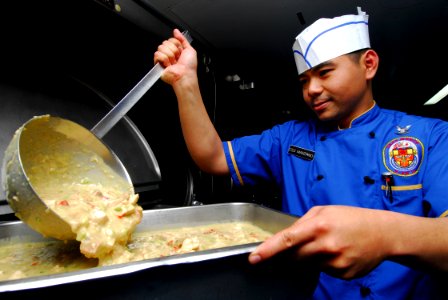 US Navy 100503-N-4044H-064 Culinary Specialist 3rd Class Jaime Manzano prepares Turkey-A-La-King for lunch aboard the Military Sealift Command hospital ship USNS Mercy (T-AH 19)