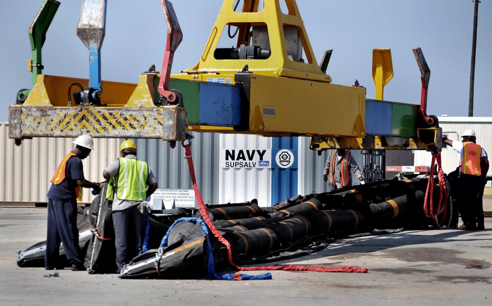 US Navy 100506-N-7367K-009 Longshoremen and personnel assigned to the Supervisor of Salvage and Diving division of Naval Sea Systems Command load an inflatable oil containment boom