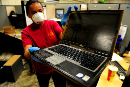 US Navy 100506-N-5862D-002 nformation Systems Technician 1st Class Latarsha Young displays one of many computers that were damaged by floodwaters at the Navy Recruiting Command storage annex
