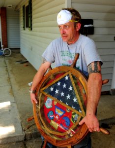 US Navy 100505-N-5862D-003 Navy housing resident Larry Stivers salvages his retirement shadow box after being allowed back to his home in the base housing area of Naval Support Activity Mid-South