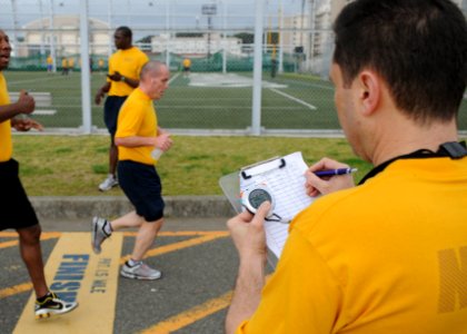 US Navy 100507-N-3283P-107 Quartermaster 1st Class Andrey Mihaylovski monitors the time during the 1.5-mile run portion of the Commander, U.S. Naval Forces Japan Physical Fitness Assessment