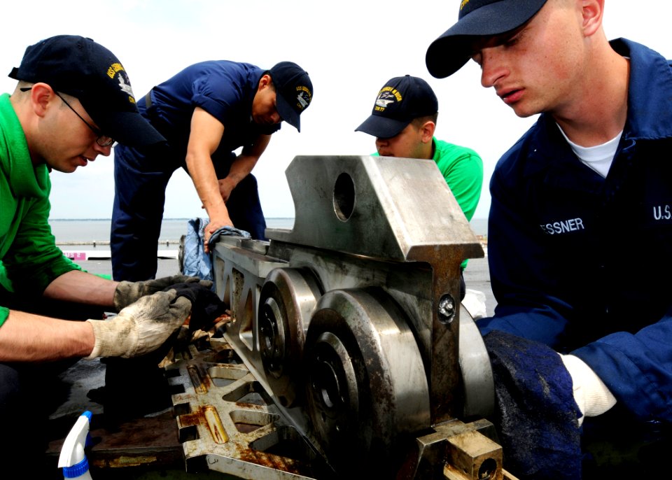 US Navy 100504-N-8913A-029 Sailors perform preventative maintenance on a catapult shuttle on the flight deck of USS George H.W. Bush (CVN 73)