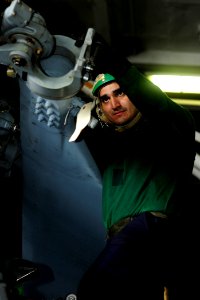 US Navy 100504-N-6604E-091 Aviation Machinist's Mate 2nd Class John Paara guides an SH-60F Sea Hawk helicopter propeller blade into place