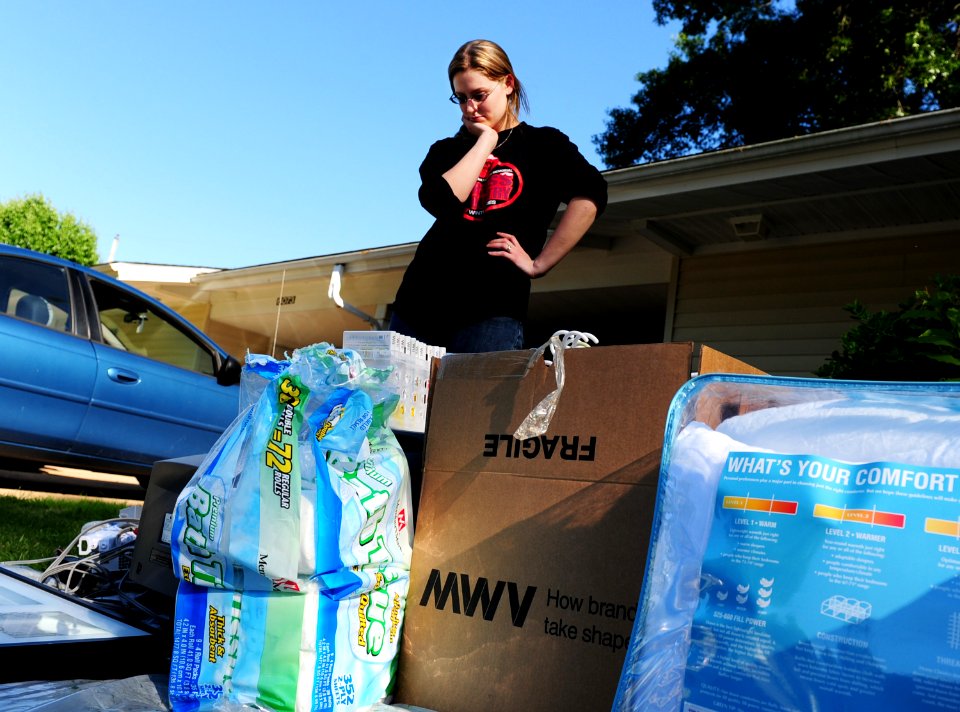 US Navy 100505-N-5862D-015 A Navy dependent looks over household items