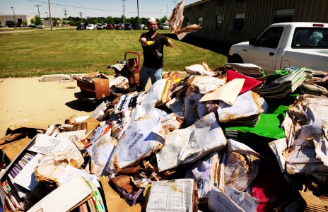US Navy 100506-N-5862D-008 Nathan Peoples piles waterlogged paperwork and equipment that was damaged by floodwaters at the Navy Recruiting Command storage annex