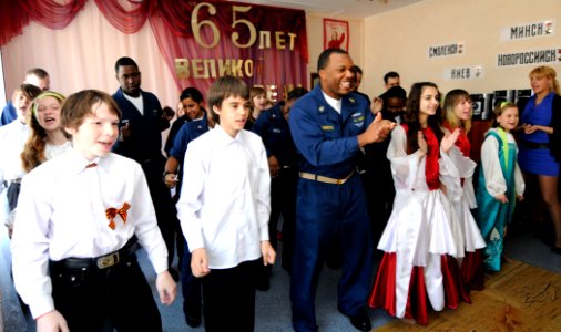 US Navy 100508-N-0864H-516 Senior Chief Information Systems Technician Okyo J. Simmons and other Sailors assigned to the U.S. 7th Fleet Command ship USS Blue Ridge (LCC 19), sing and dance with children at the Mayak Children's