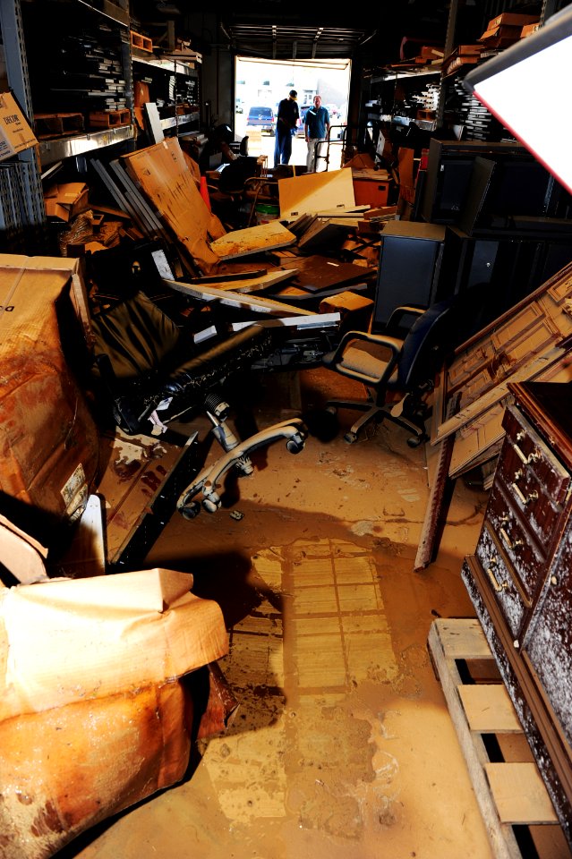 US Navy 100506-N-5862D-006 Military and civilian employees survey a room that was damaged by floodwaters at the Navy Recruiting Command storage annex