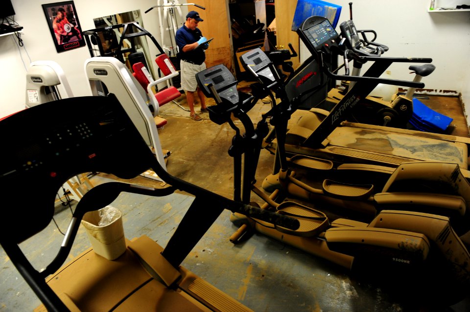 US Navy 100506-N-5862D-007 Randy Roe, a contractor with Duraclean, measures the square footage of rooms like the mini gym that were damaged by flood waters at the Navy Recruiting Command storage annex
