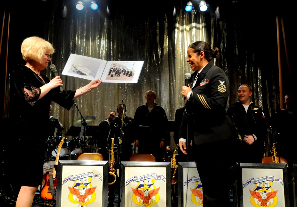 US Navy 100509-N-7280V-305 Chief Musician Luslaida Barbosa presents photos on behalf of the U.S. 7th Fleet Band during a combined performance with the Pacific Brass Orchestra