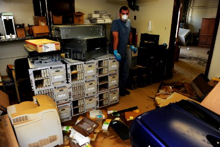 US Navy 100506-N-5862D-003 Interior Communications Electrician 1st Class Matthew Ford surveys a computer storage room that was damaged by floodwaters at the Navy Recruiting Command storage annex