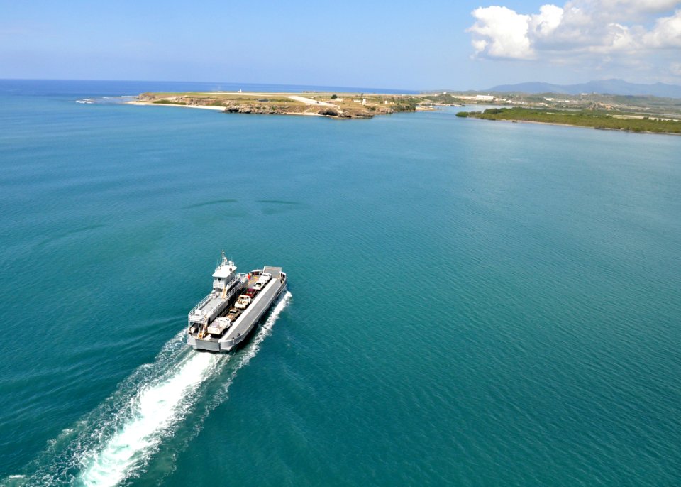 US Navy 100506-N-8241M-286 An aerial view of a yard boat ferry crossing the harbor at Naval Station Guantanamo Bay, Cuba