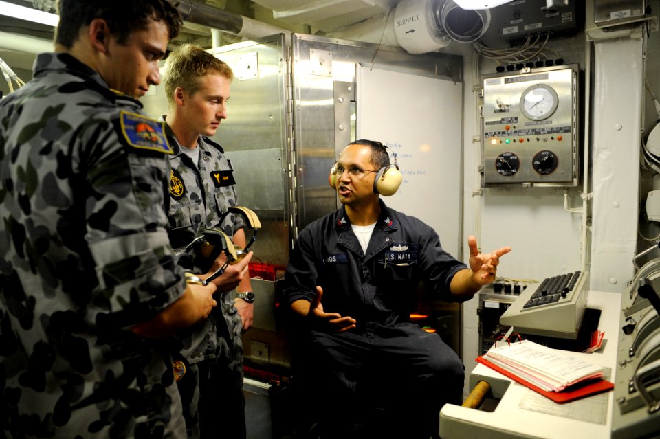 US Navy 100506-N-8959T-202 Gas Turbine Systems Technician 2nd Class Jose Ramos explains the ship's machinery consoles to Australian Navy Able Seamen