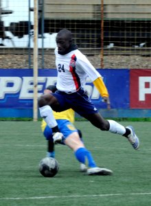 US Navy 100510-N-7478G-409 Personnel Specialist 3rd Class Ernest Baah jumps to avoid a Russian player trying to steal the soccer ball