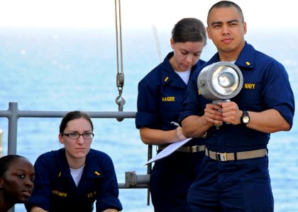 US Navy 100510-N-1082Z-043 Ensign Miguel Bengson, from Baltimore, practices flashing light signals during junior officer training aboard the amphibious dock landing ship USS Ashland (LSD 48)