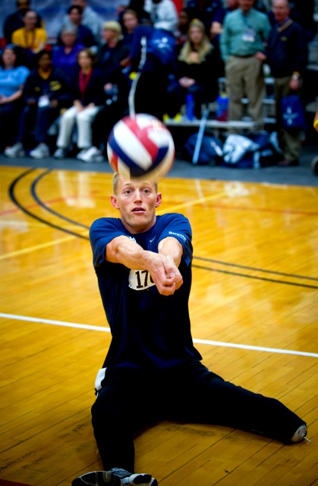 US Navy 100511-N-6932B-190 Parachute Rigger 3rd Class Michael Johnston bump-passes the ball to a teammate during a sitting volleyball game against the Army team at the inaugural Warrior Games