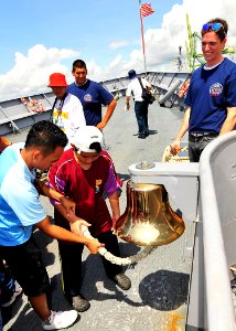 US Navy 100508-N-7643B-030 A group of children from the Society for the Management of Autism Related Issues in Training, Education and Resources (SMARTER) school of Brunei rings the forecastle bell during a tour of the guided-m photo